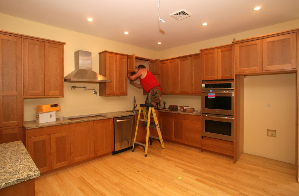 John Bieber of Bieber Woodworks installs cabinets in the kitchen of one of two apartments at 443 S. Warren St.