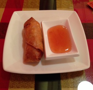The egg roll comes presented on a plate and next to a dish of duck sauce. Photo by Christopher Malone