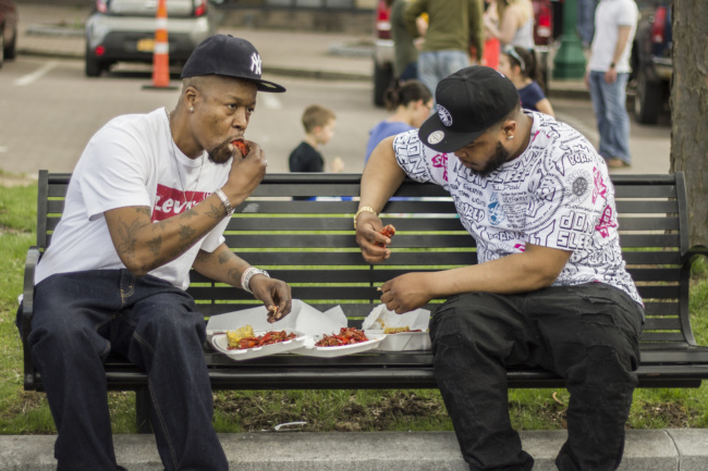 Two men were able to grab seats on a park bench, using it as both a chair and a table for their food.