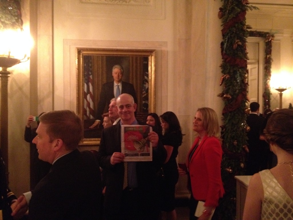 Jeff Kramer poses in front of a portrait of Bill Clinton. 