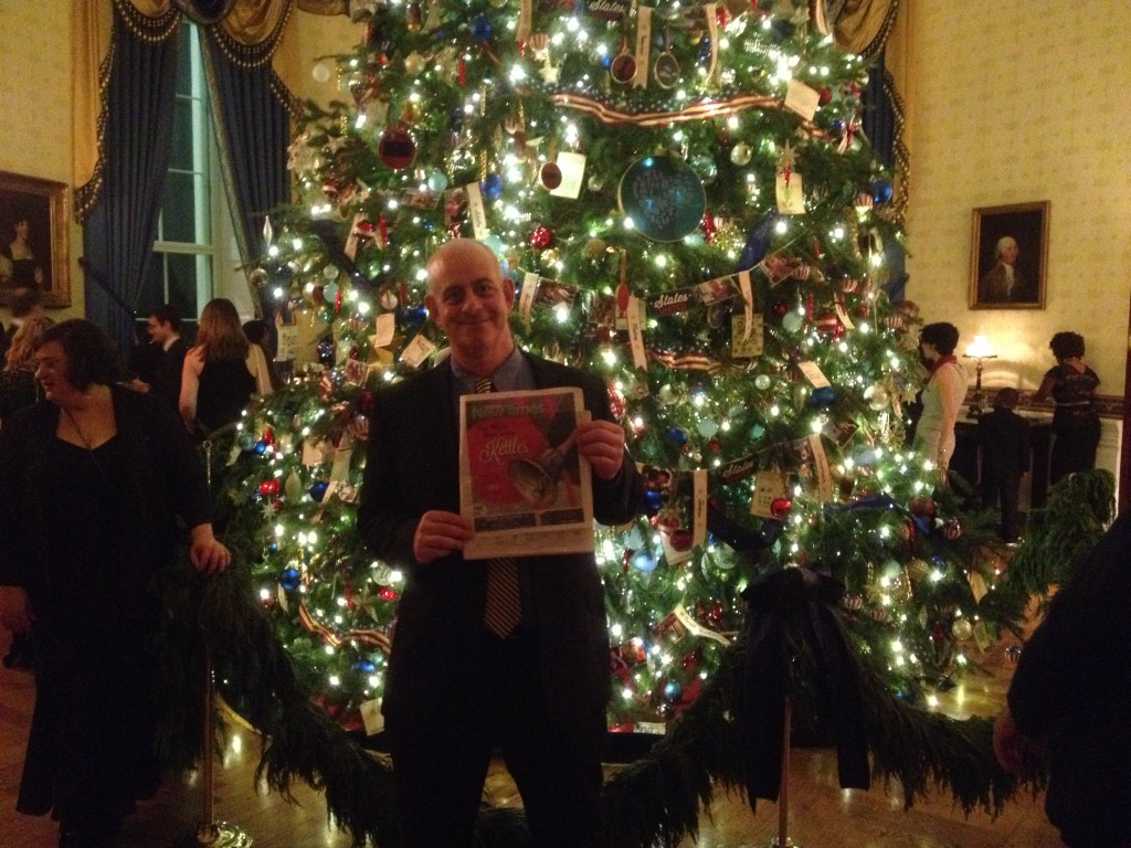 Jeff Kramer posing with a Syracuse New Times in front of the White House Christmas Tree.