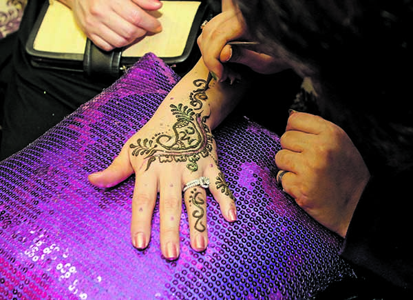 SK Henna of Syracuse paints a hand at The Underground Show Thursday at Marissa's Fortress of Beauty during Day 2 of Syracuse Fashion Week.