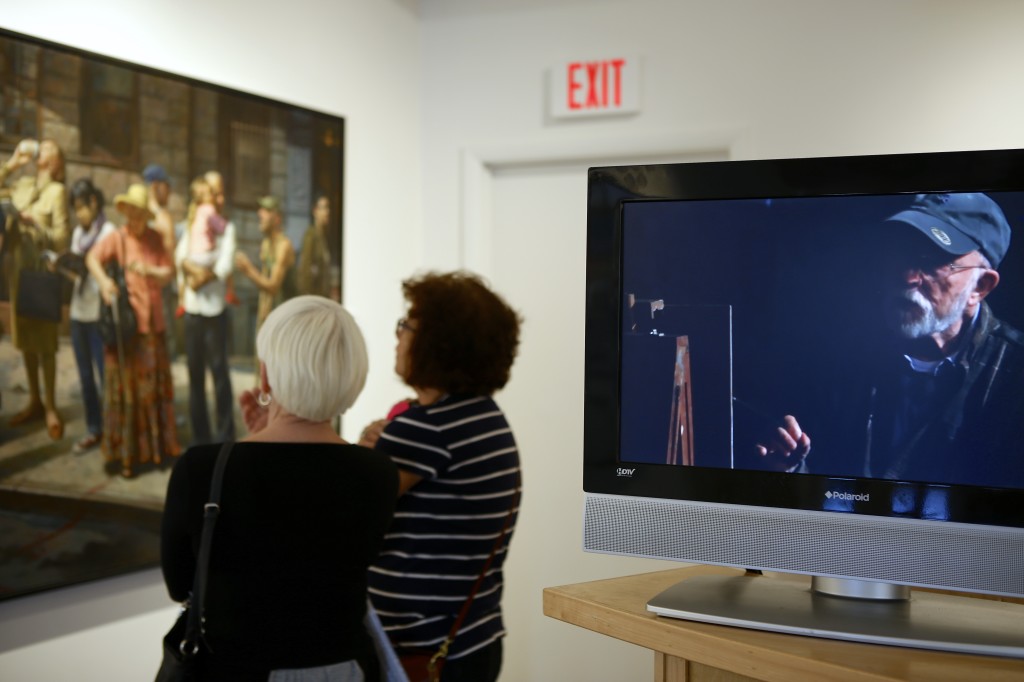 Gallery visitors view BUS STOP while a video featuring the artist Max Ginsberg plays.