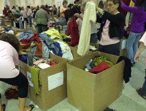 Shoppers go through cardboard boxes of clothing looking for bargains at the annual Flax Barn Sale April 25-27 in Ithaca.