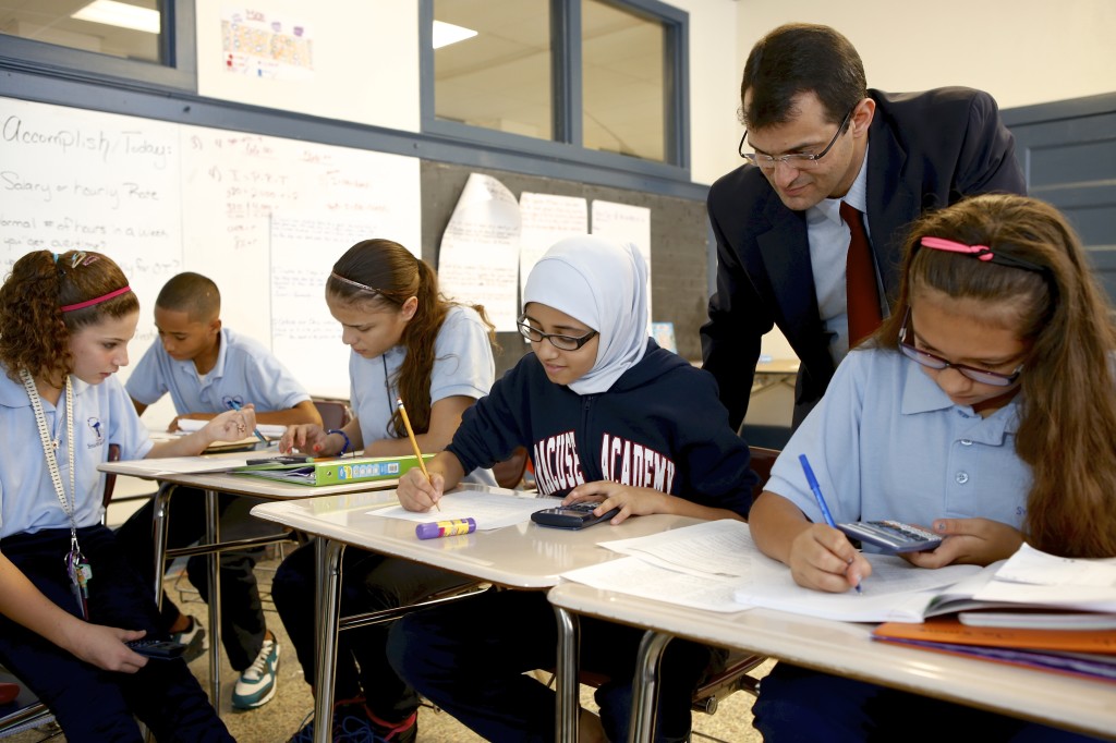 Hayali assisting students with schoolwork. Michael Davis Photo | Syracuse New Times.