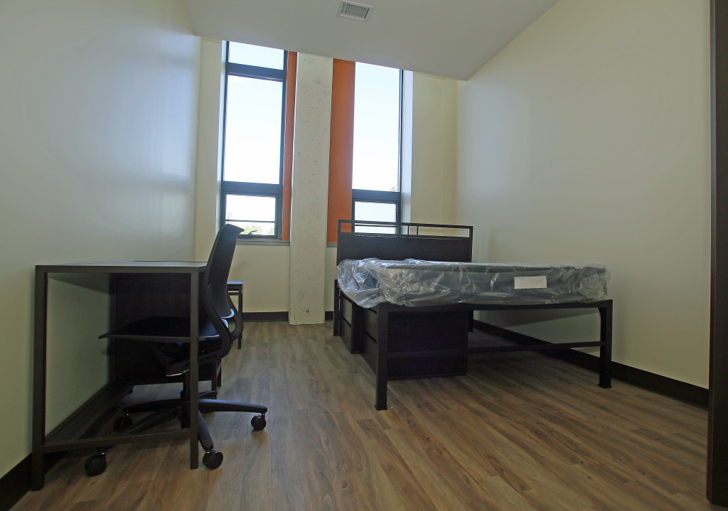 The bedrooms at Creekwalk Commons are furnished with queen-size beds and desks. Underbed storage units can be moved and used as dressers or nightstands. Photo by Gloria Wright | Syracuse New Times