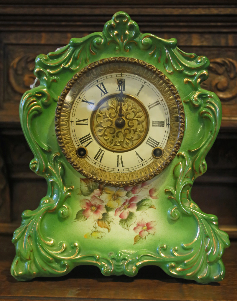 A green porcelain clock with flowers is available at Syracuse Antiques Exchange for $250.