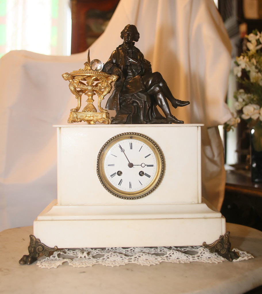 A white marble clock with a porcelain dial and topped with a bronze figure is available at Syracuse Antiques Exchange for $995.