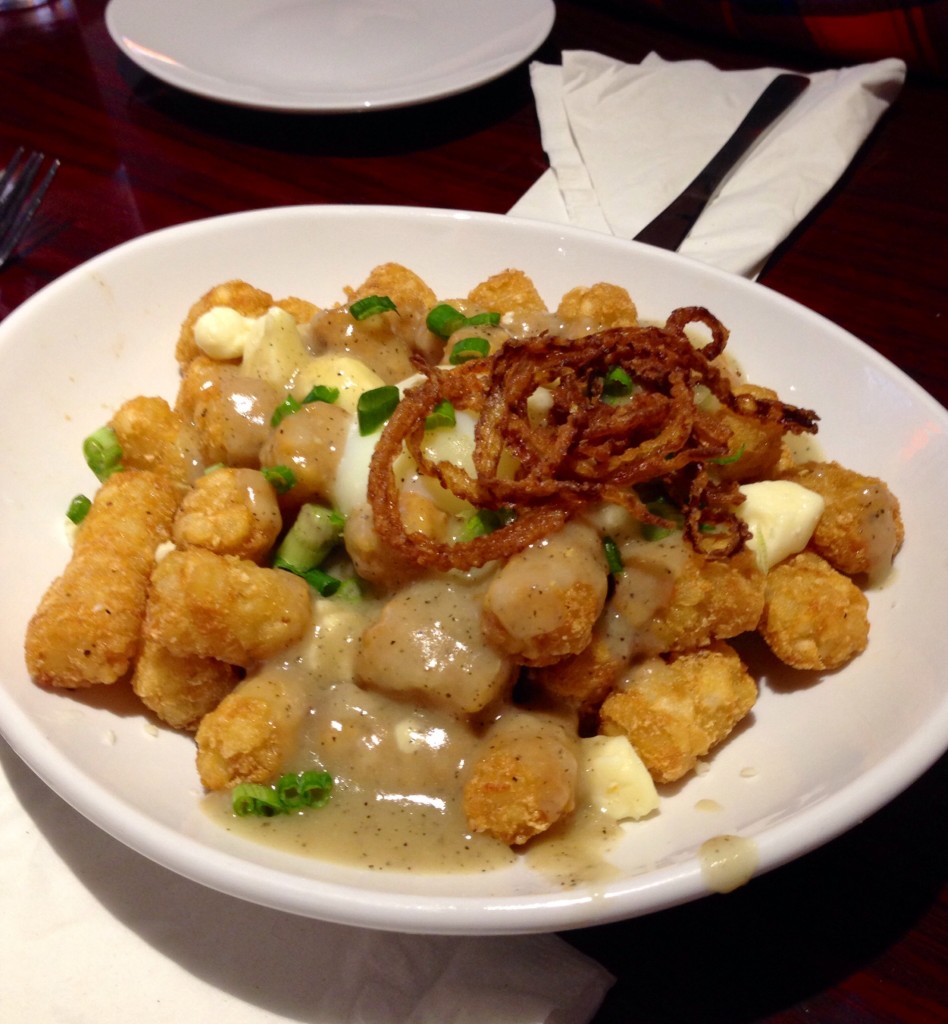 Breakfast Poutine -- tots, NY cheese curds, bourbon au poivre, poached egg, scallions and french-fried-frizzled onions.  Photo: Christopher Malone