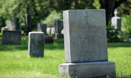 An old, worn rectangular headstone with Thomas F. Butler's name on it. Above are the names of his parents, who he was buried near.