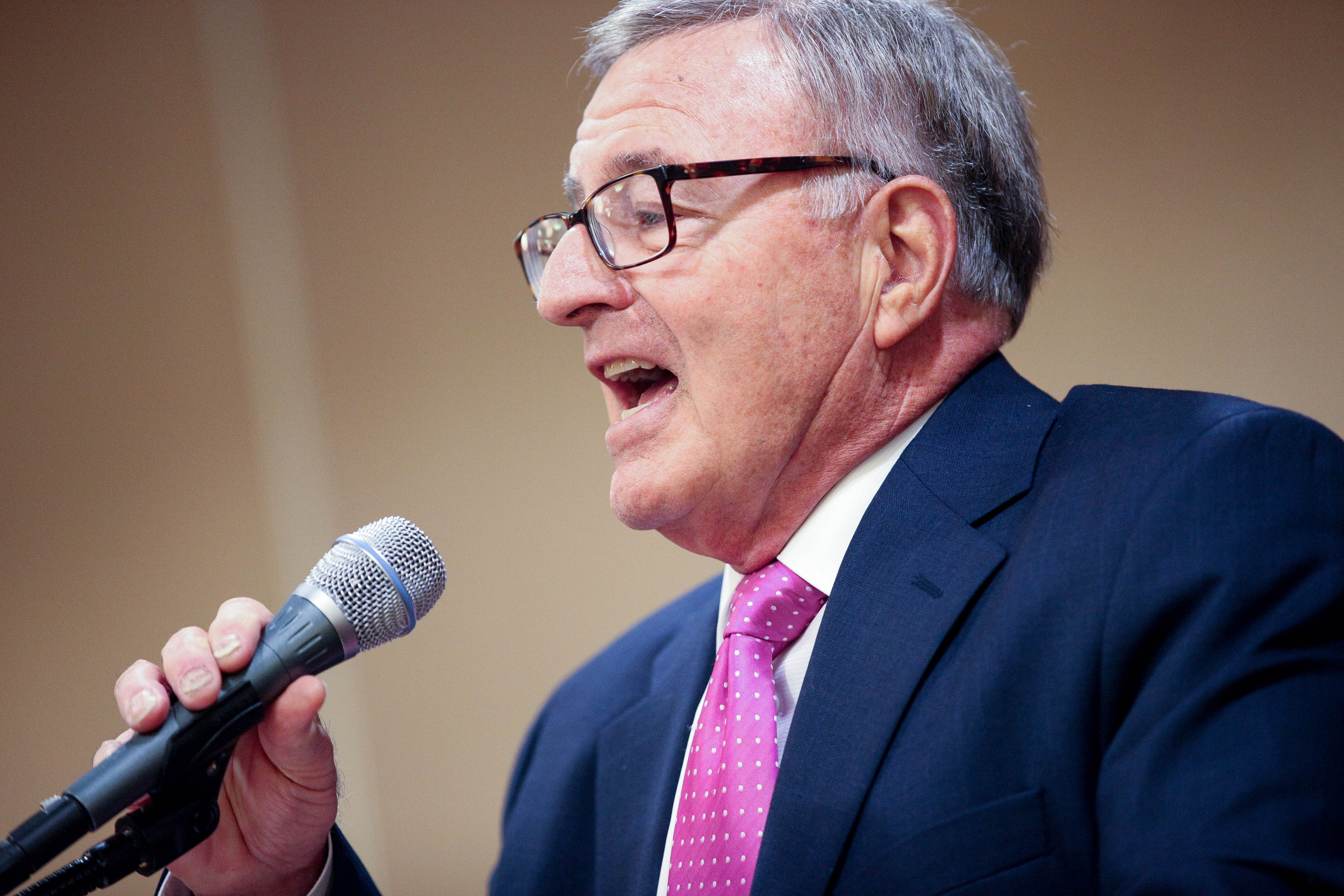 A close-up shot of Sen. John DeFrancisco as he speaks into a microphone.
