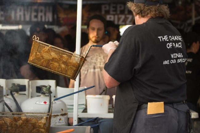A person pulls a basket of wings out of a fryer at Wing Fest 2018
