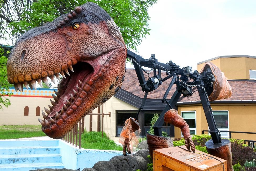 A robotic dinosaur has a lifelike head but a steel frame body, waiting to be completed.