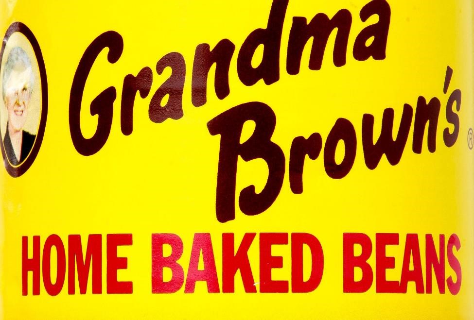 Grandma Brown's Baked Beans cans have an old-fashioned logo, with brown and red text on a yellow background, with a picture of Grandma Brown and a casserole dish of beans.