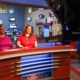 Two Spectrum News achnors sit in the studio, about to go live.