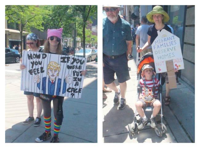 Signs from the Families Belong Together rally. On the left, a person in a pink pussy hat holds a poster depicting donald trump behind bars with the caption "How'd you feel if you were put in a cage?" On the right, a woman holds a sign that says "Migrant families deserve homes not jails." She's also pushing a toddler in a stroller.