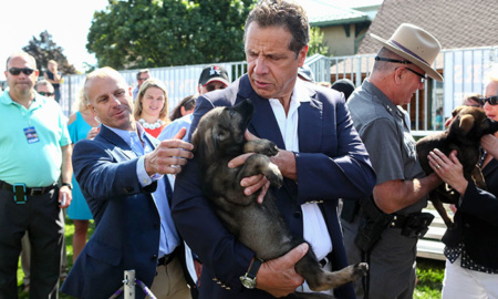 Gov. Andrew Cuomo holds a small dog in his arms at the state fair. This latest blog post discusses his lax attitude toward rampant state government corruption.