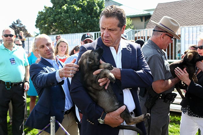 Gov. Andrew Cuomo holds a small dog in his arms at the state fair. This latest blog post discusses his lax attitude toward rampant state government corruption.